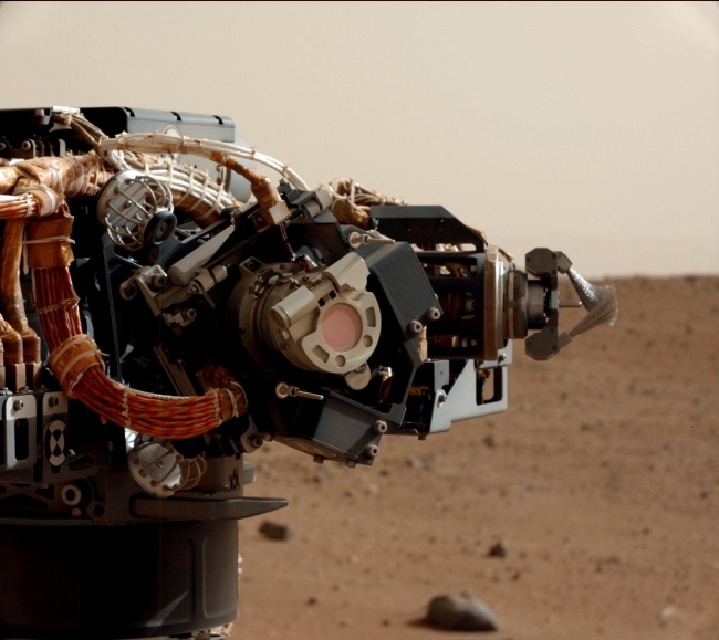 Camera on Curiosity's Arm as Seen by Camera on Mast,  The left eye of the Mast Camera (Mastcam) on NASA's Mars rover Curiosity took this image of the camera on the rover's arm, the Mars Hand Lens Imager (MAHLI)...