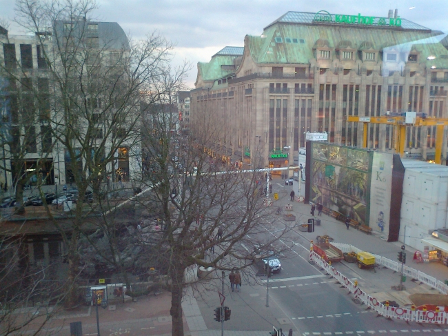 End of Kö, Corner Kaufhof Kö, as seen from Meyersche Buchhandlung: across the river Düssel is Aberchrombie & Fitch's T-shirt and Hoodie Shoppe, Boss on the corner of Breidenbacher Hof and...